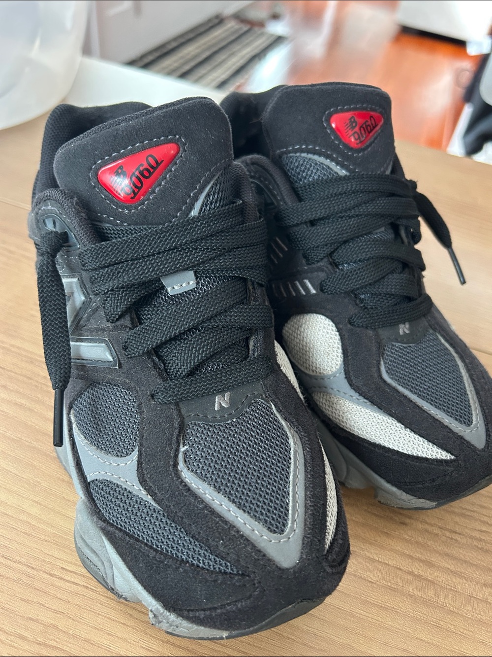 New Balance Kids Black and Gray Sneakers with Red Tongue Accents